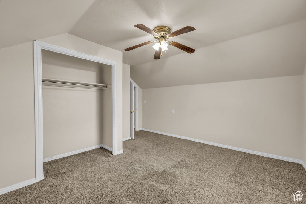 Unfurnished bedroom featuring vaulted ceiling, a closet, and carpet floors