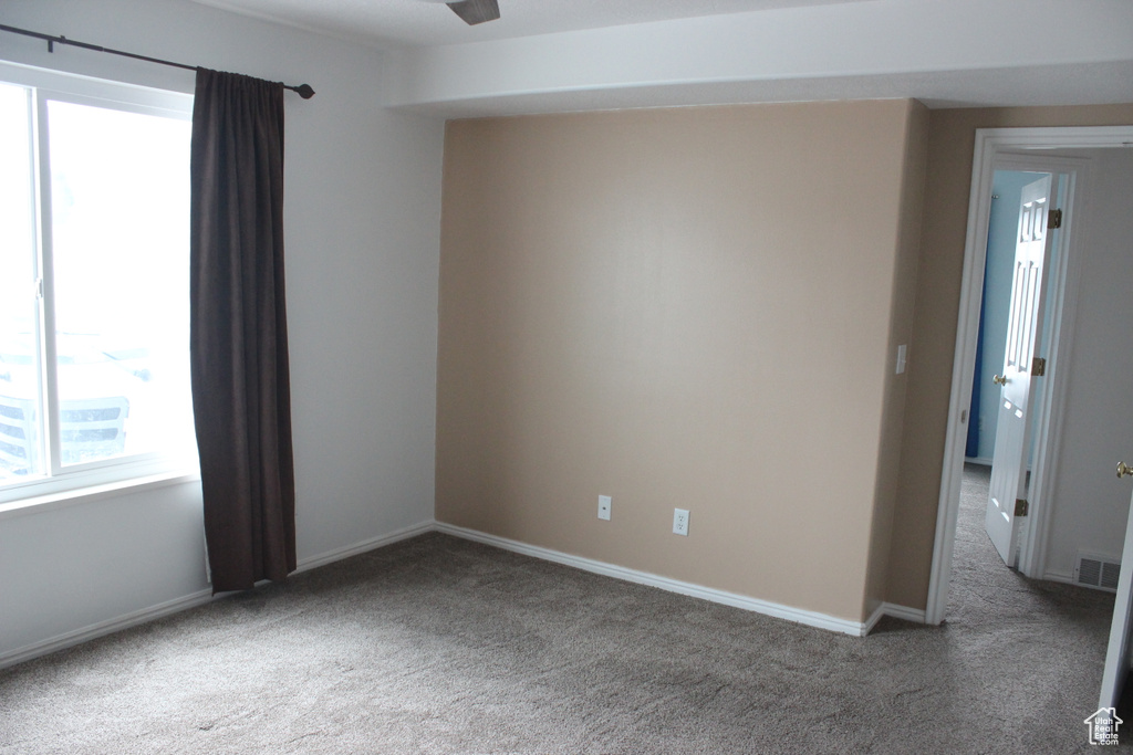 Unfurnished room featuring baseboards, visible vents, ceiling fan, and carpet flooring