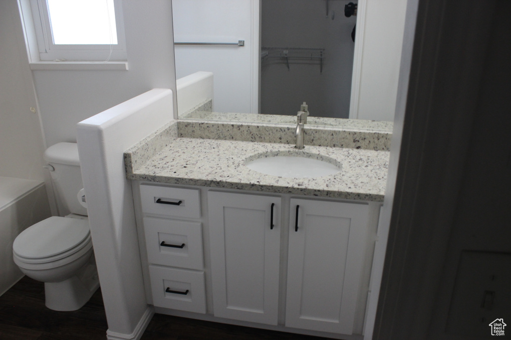 Full bath featuring wood finished floors, toilet, and vanity