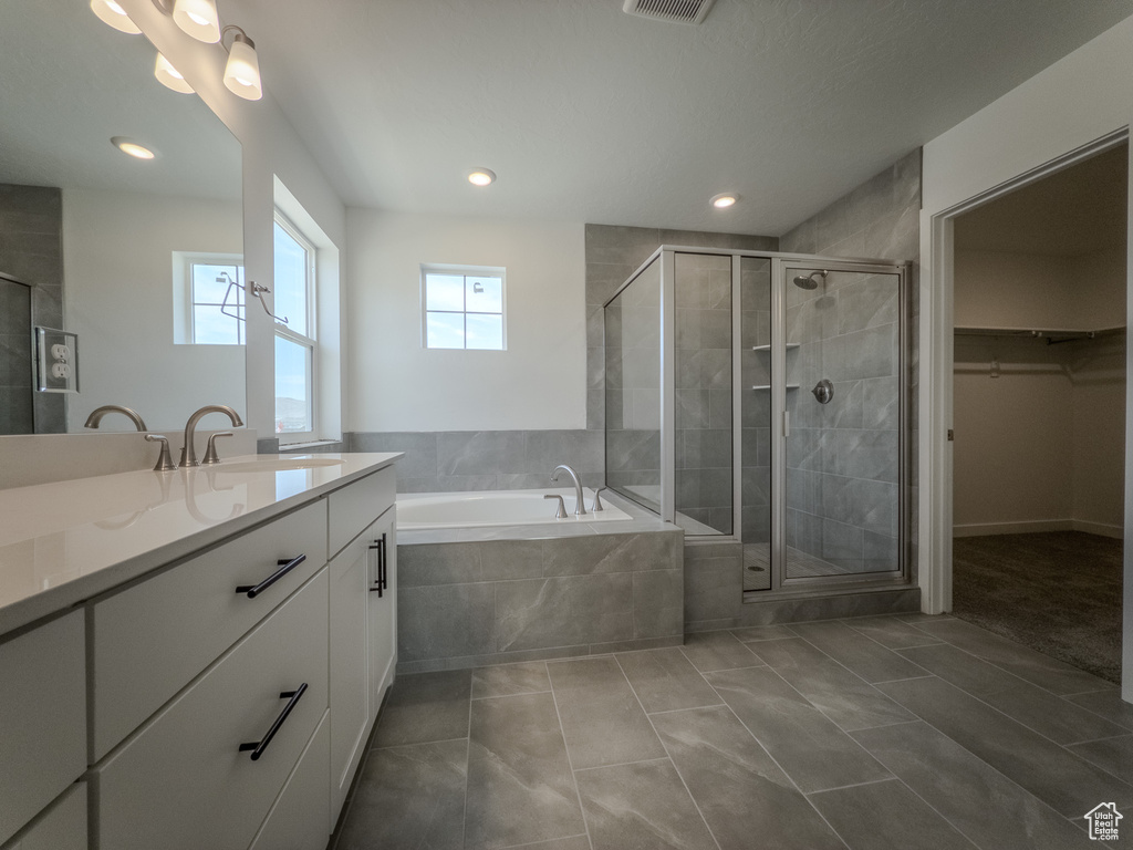 Full bathroom with vanity, a bath, a shower stall, a walk in closet, and recessed lighting