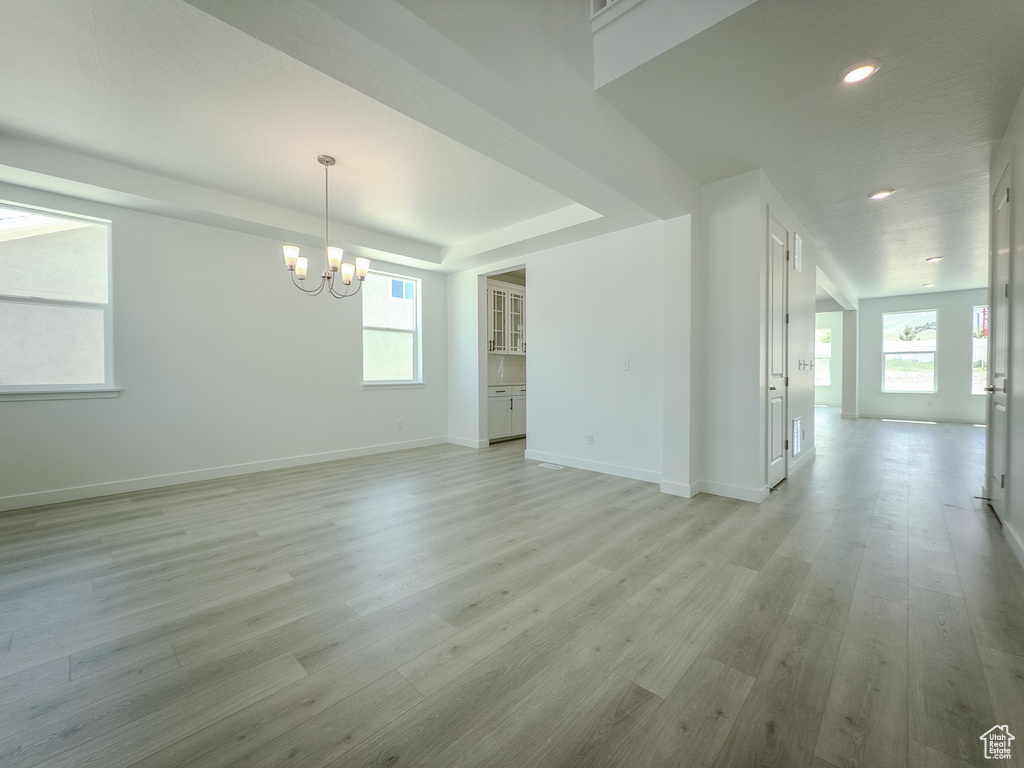 Unfurnished room with a chandelier, light wood-style flooring, healthy amount of natural light, and recessed lighting