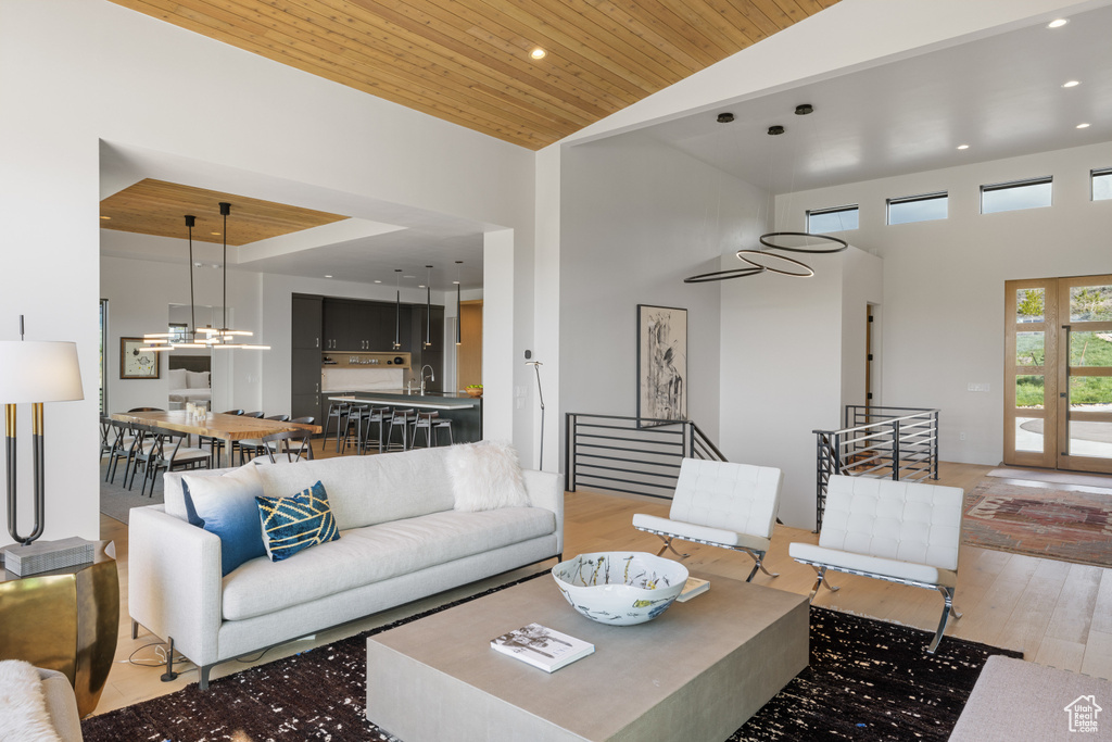 Living area with high vaulted ceiling, light wood-type flooring, wooden ceiling, and recessed lighting