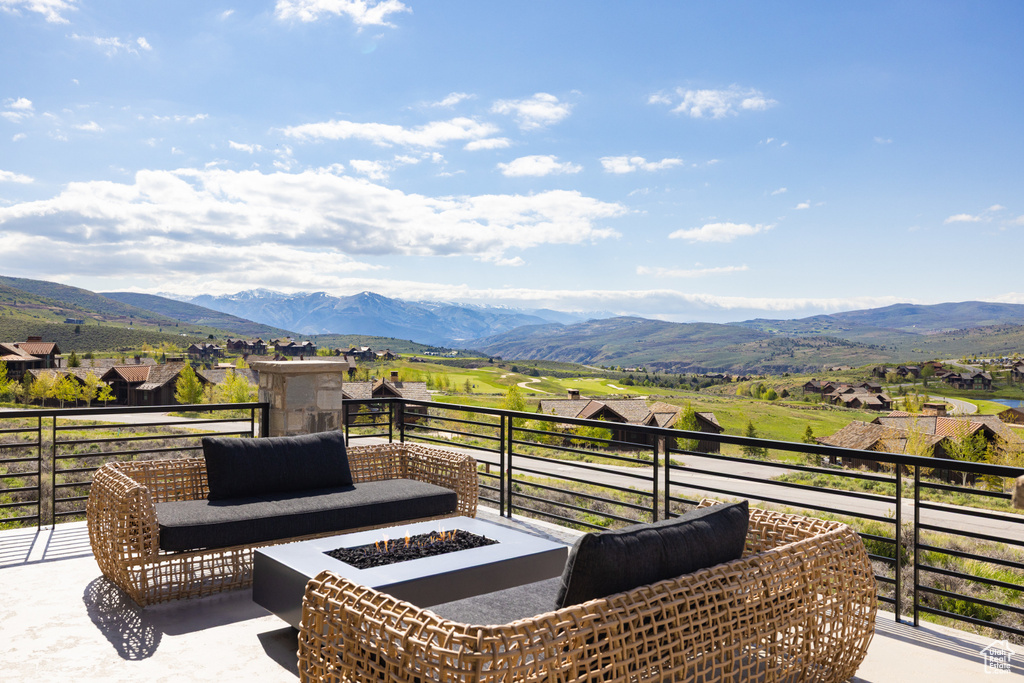 View of patio / terrace with a balcony, an outdoor fire pit, and a mountain view