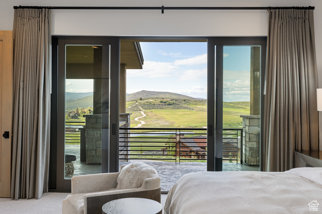 Bedroom featuring a mountain view, carpet floors, and access to outside
