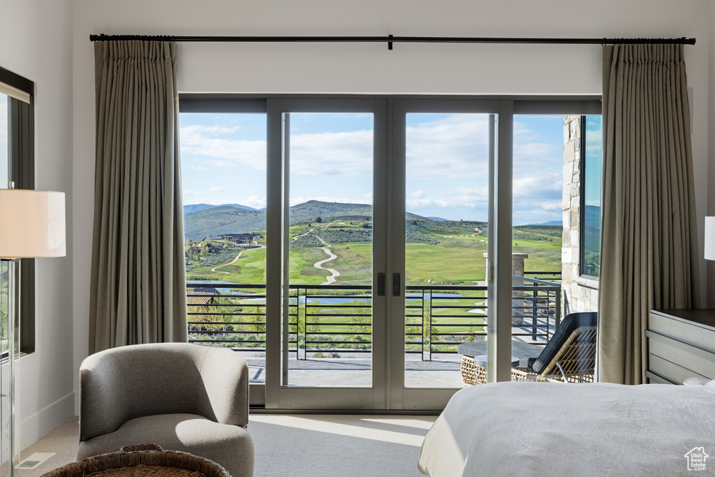 Bedroom featuring a mountain view, view of golf course, and access to outside