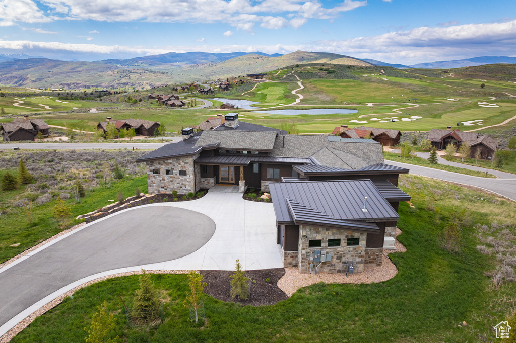 View from above of property with a golf club and a water and mountain view