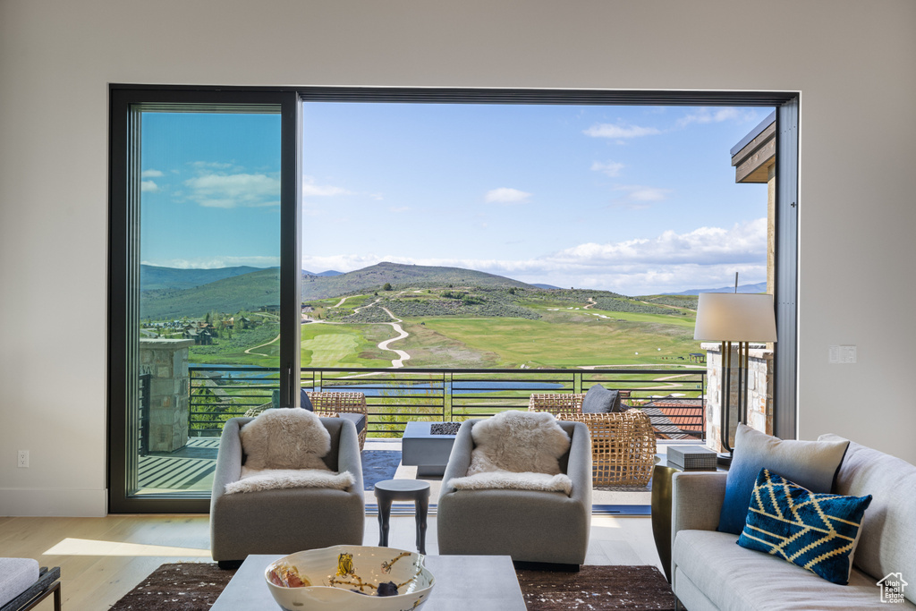 Living area with a mountain view, wood finished floors, plenty of natural light, and baseboards
