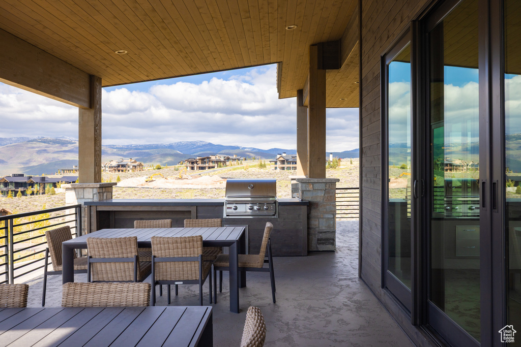 Wooden deck featuring a mountain view and outdoor dining space
