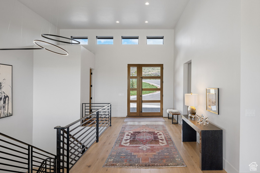 Entrance foyer with wood finished floors, a high ceiling, and recessed lighting