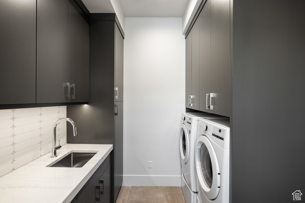 Laundry room with cabinet space, washer and clothes dryer, and baseboards