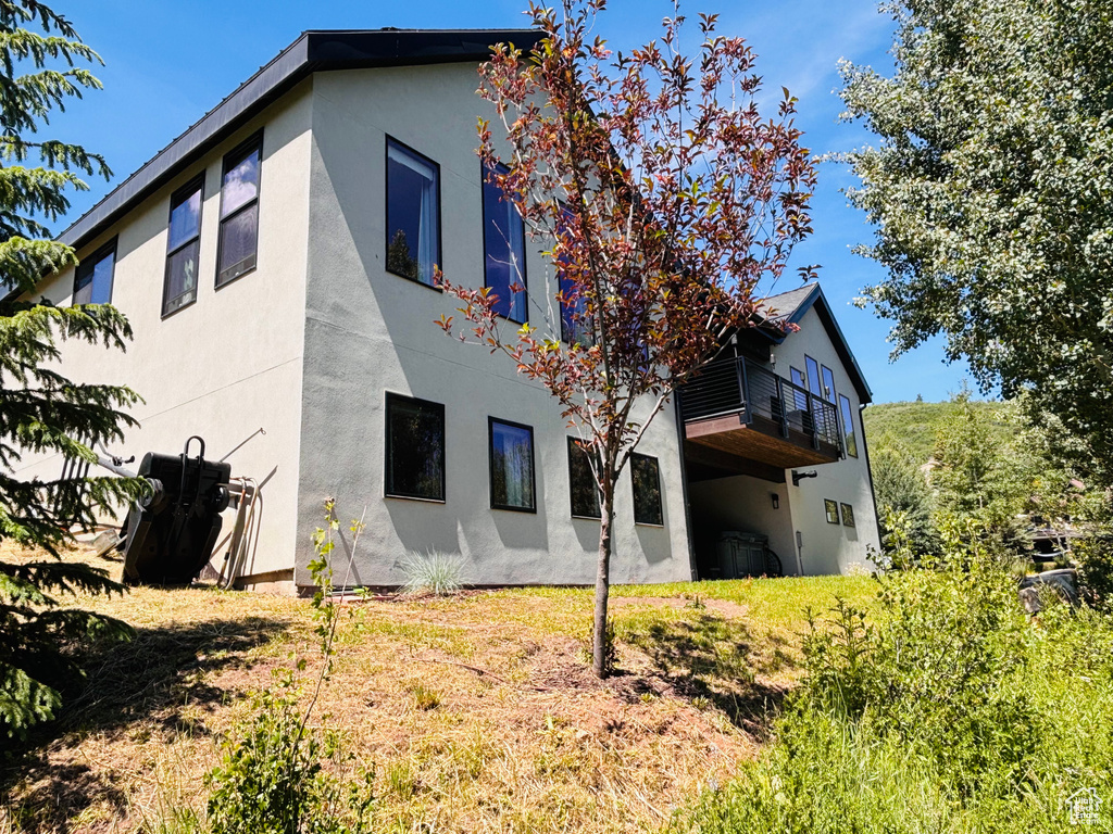 Back of property with stucco siding and a balcony