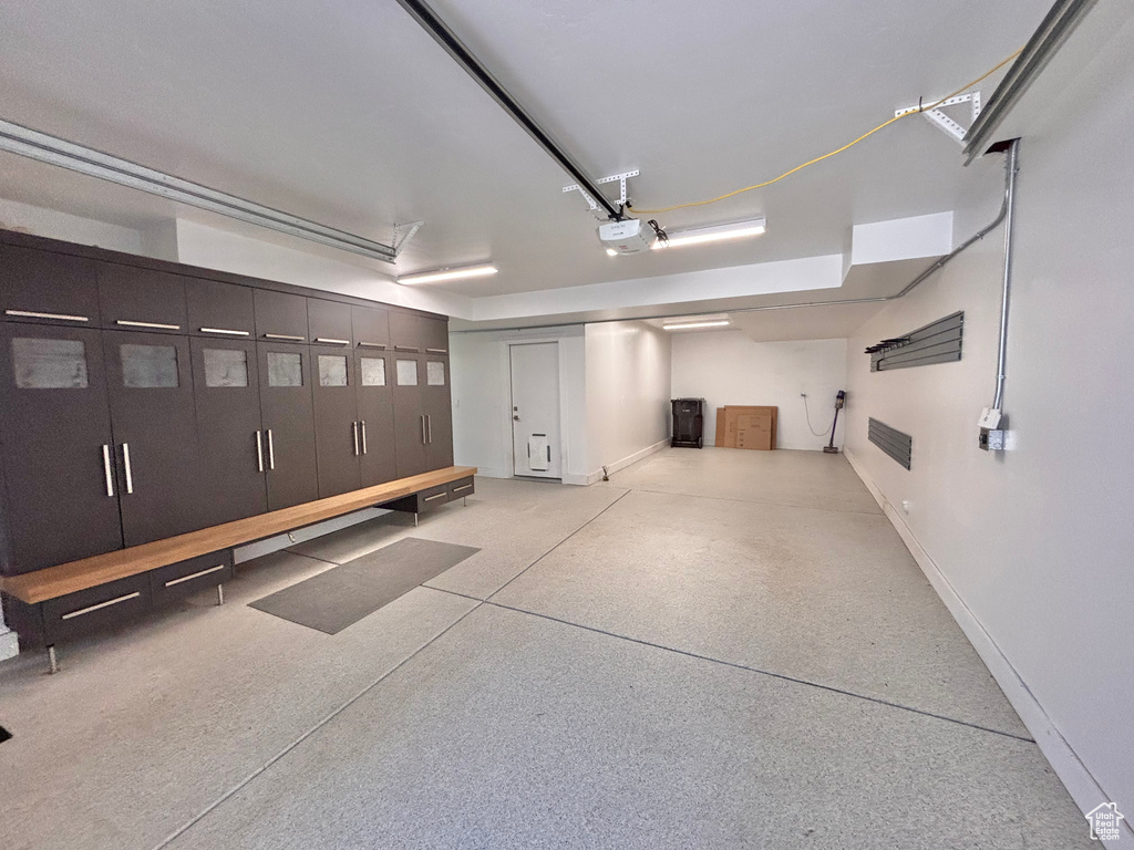 Garage with baseboards and a garage door opener