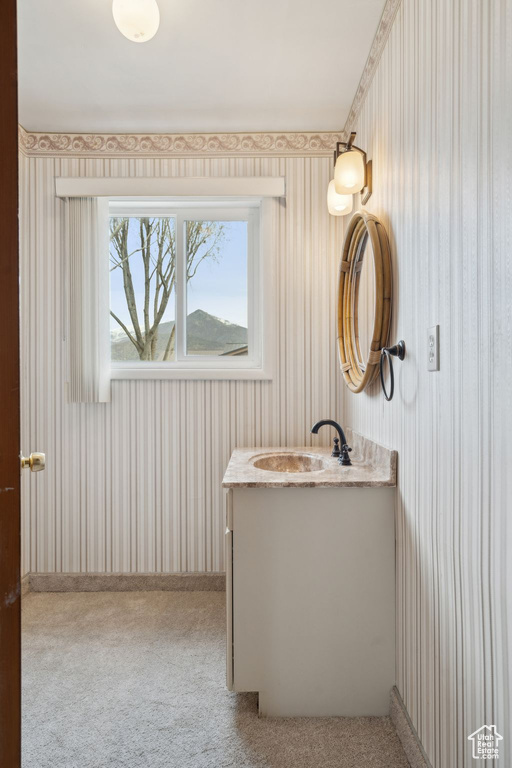 Bathroom with wallpapered walls and vanity