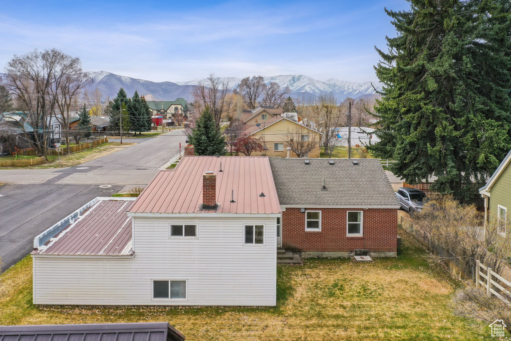 Exterior space with fence, a mountain view, and a yard