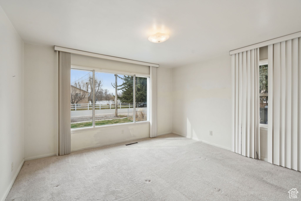 Empty room with visible vents and carpet flooring