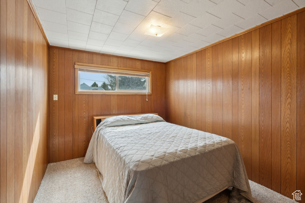 Bedroom with carpet flooring and wood walls