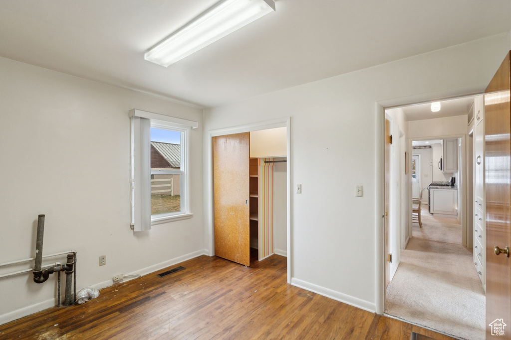 Unfurnished bedroom featuring light wood-type flooring, a closet, baseboards, and visible vents