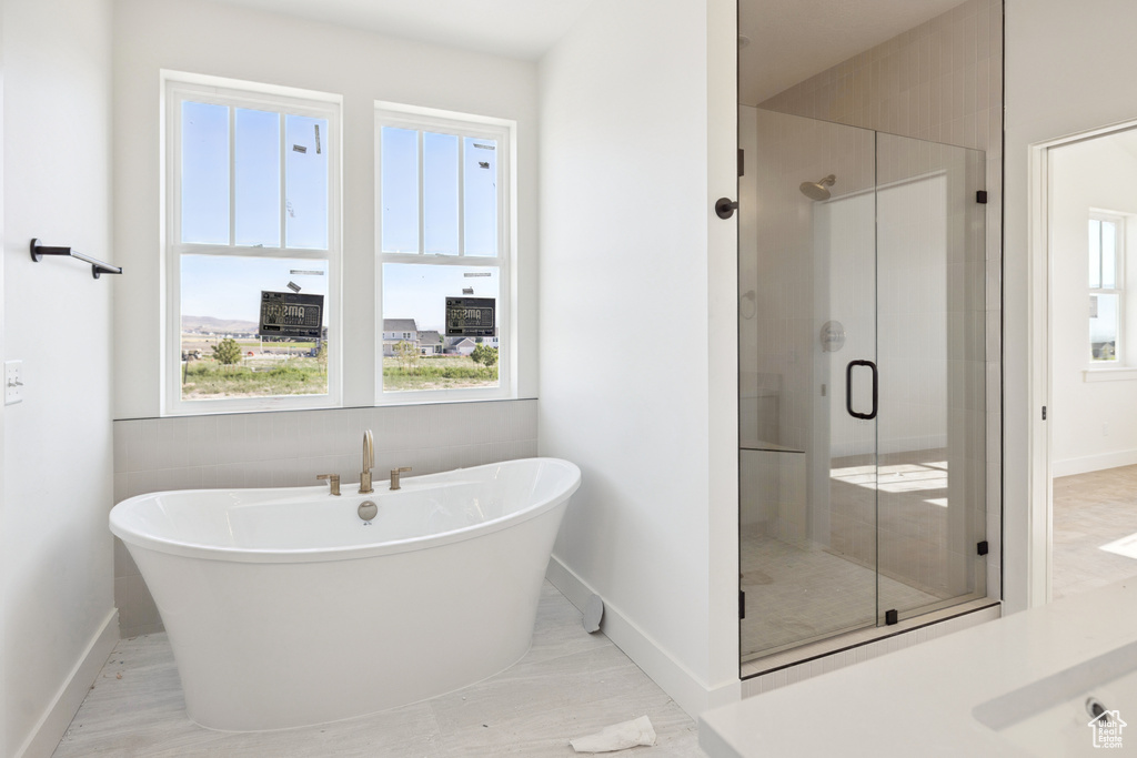 Full bathroom featuring a stall shower and a soaking tub