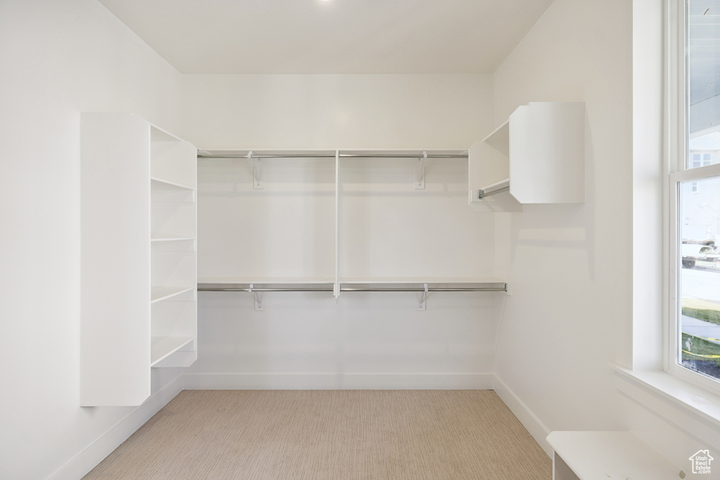 Walk in closet featuring light colored carpet