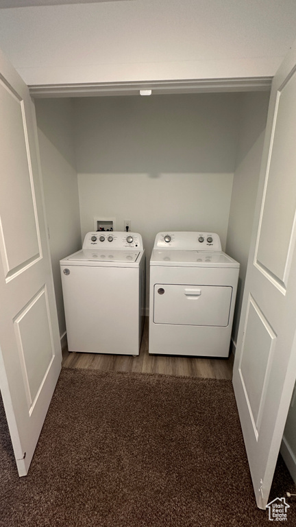 Clothes washing area with laundry area, dark wood-style flooring, and separate washer and dryer