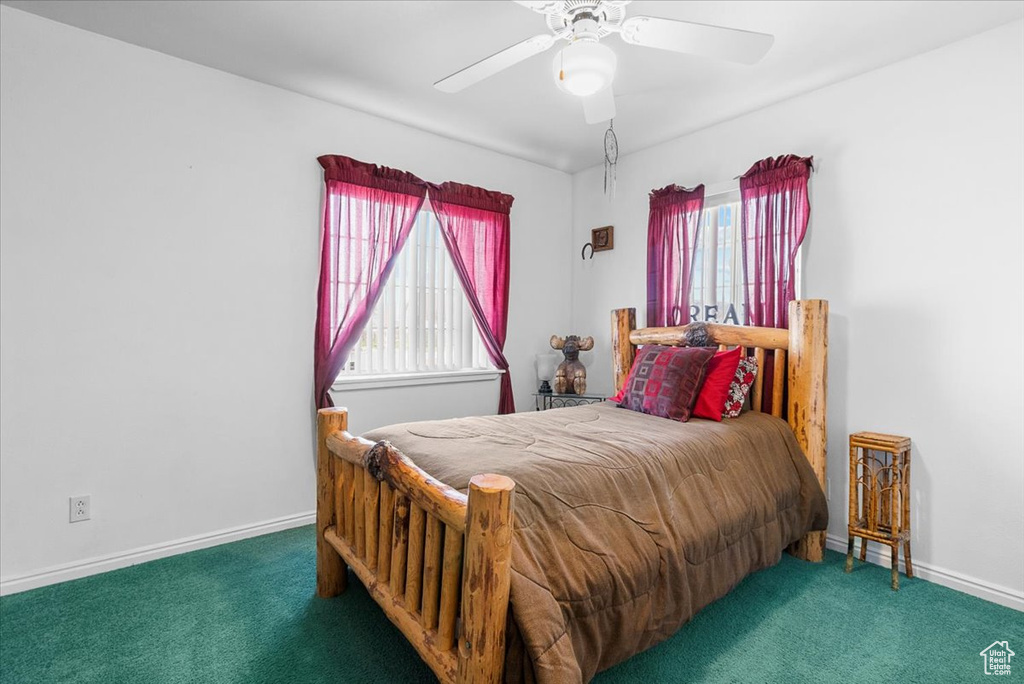 Carpeted bedroom featuring baseboards and ceiling fan