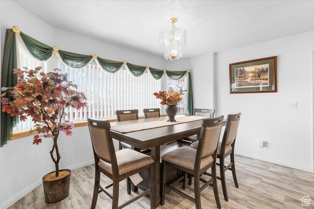Dining room featuring an inviting chandelier, plenty of natural light, and light wood-style floors