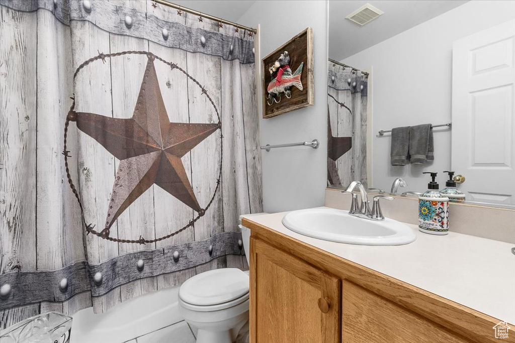 Bathroom featuring toilet, vanity, and visible vents