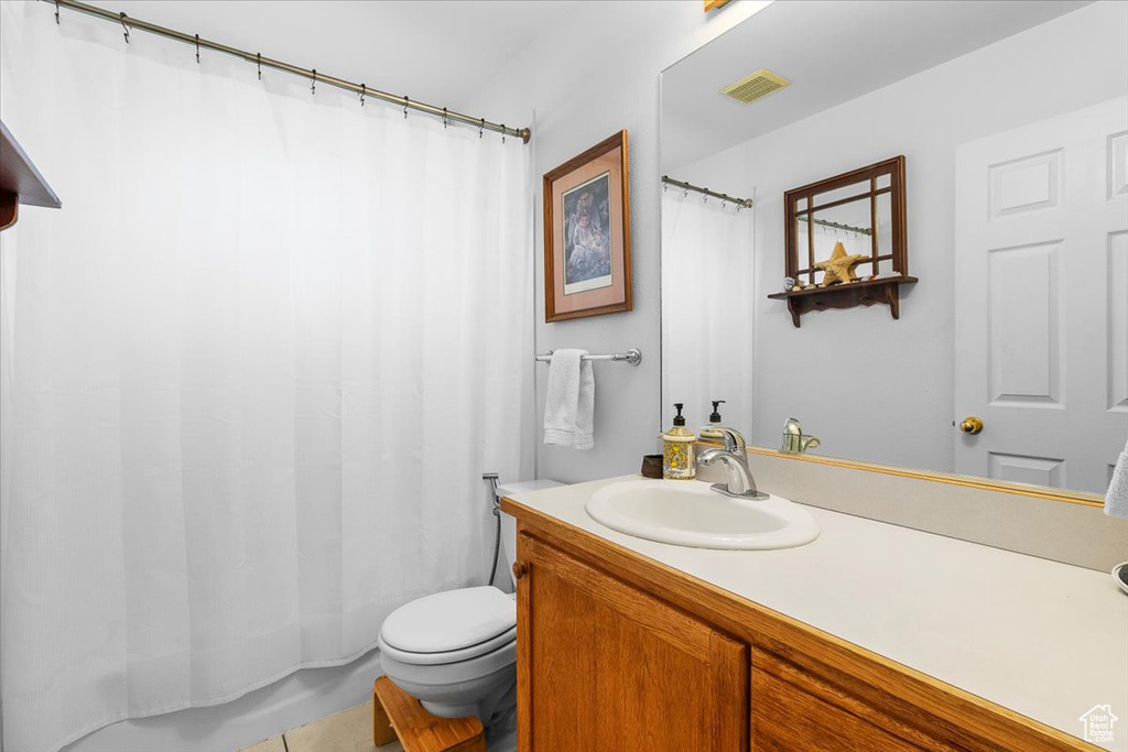 Bathroom featuring toilet, vanity, shower / bathtub combination with curtain, and visible vents