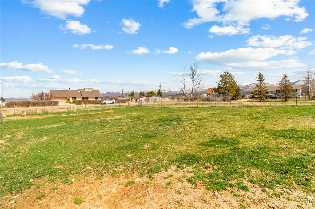 View of yard with fence and a rural view