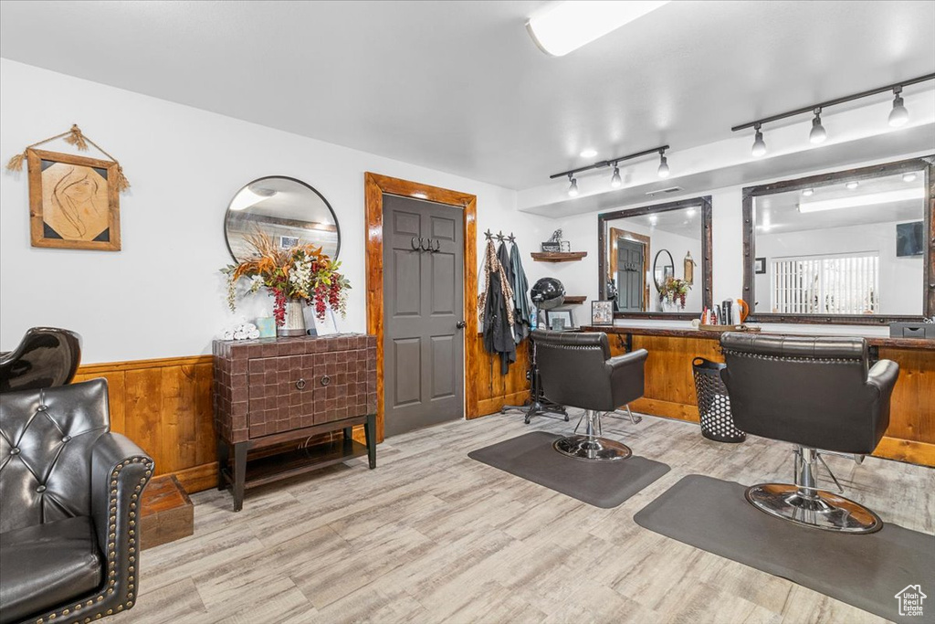 Home office with light wood finished floors, wainscoting, and wooden walls