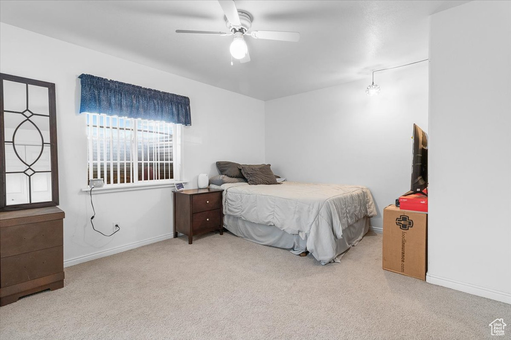 Carpeted bedroom with baseboards and a ceiling fan