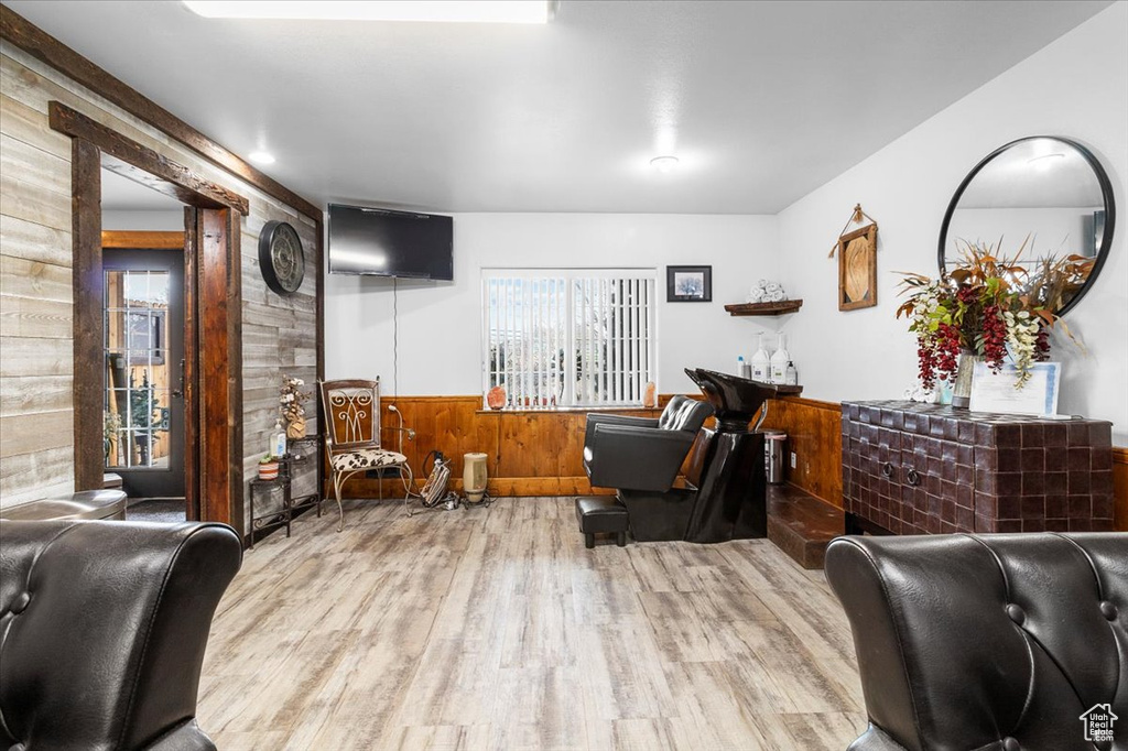 Living room featuring a wainscoted wall, wooden walls, and wood finished floors