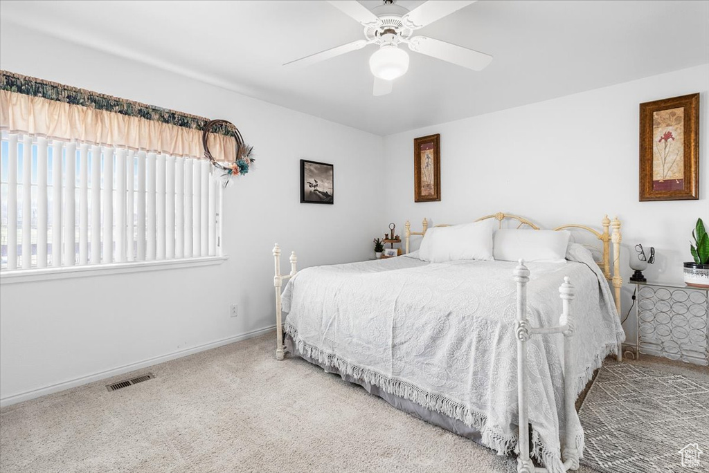 Bedroom with baseboards, carpet flooring, visible vents, and a ceiling fan