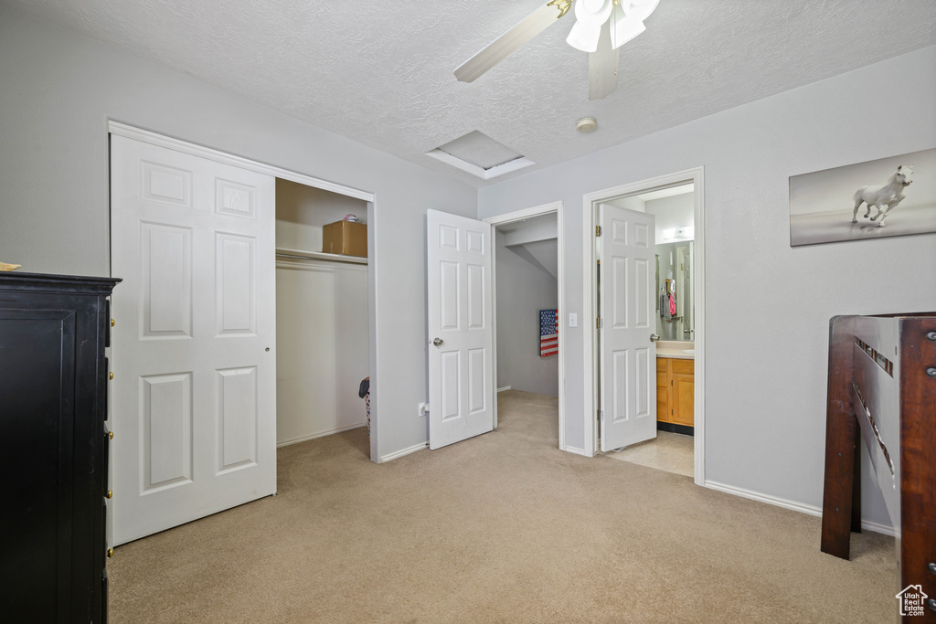 Bedroom featuring light carpet, a closet, ceiling fan, and a textured ceiling