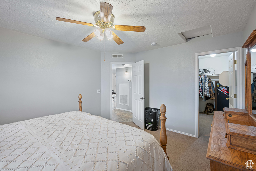 Bedroom with a walk in closet, attic access, carpet, visible vents, and a closet