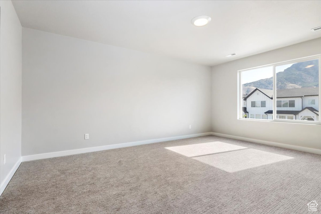 Carpeted spare room with baseboards and visible vents