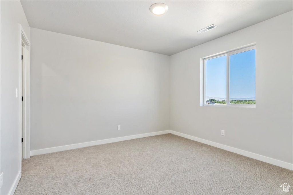 Unfurnished room with carpet flooring, baseboards, and visible vents