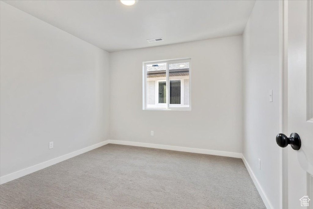Carpeted spare room with baseboards and visible vents