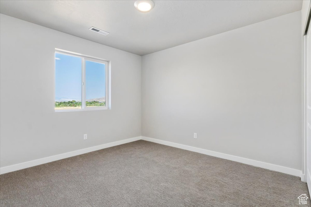 Unfurnished room with baseboards, visible vents, and carpet flooring