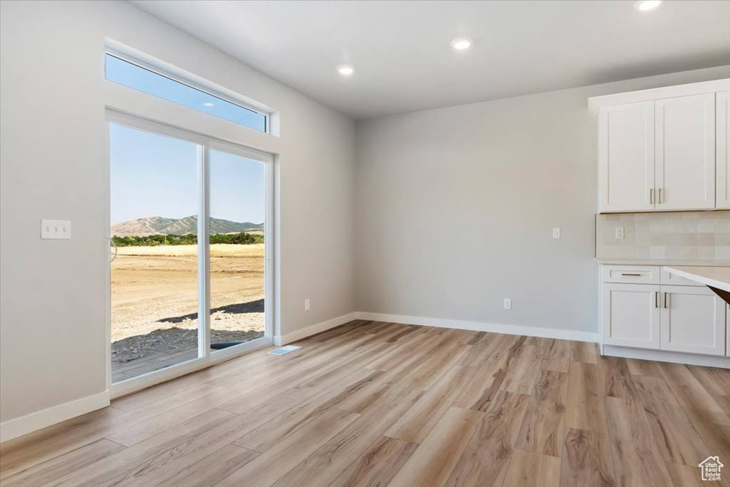 Interior space with baseboards, recessed lighting, and light wood-type flooring