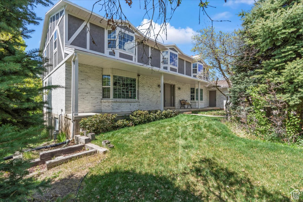 View of front of property with a porch and a front yard