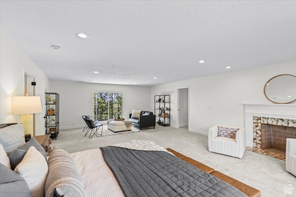 Bedroom with baseboards, a fireplace with flush hearth, recessed lighting, and light colored carpet