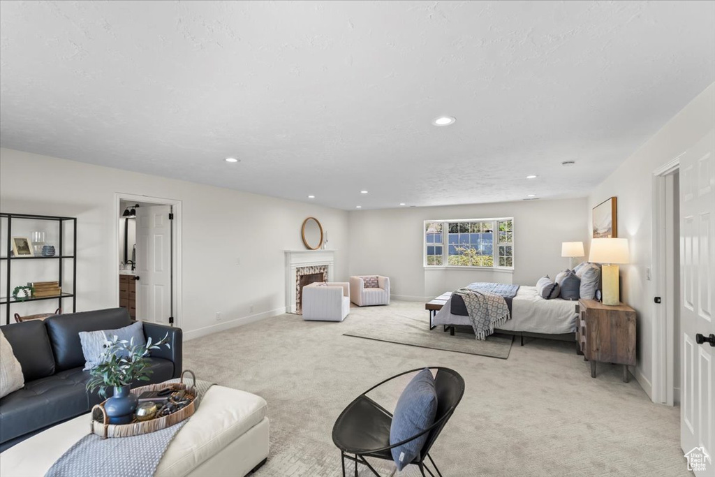 Living room with baseboards, light carpet, a premium fireplace, and recessed lighting