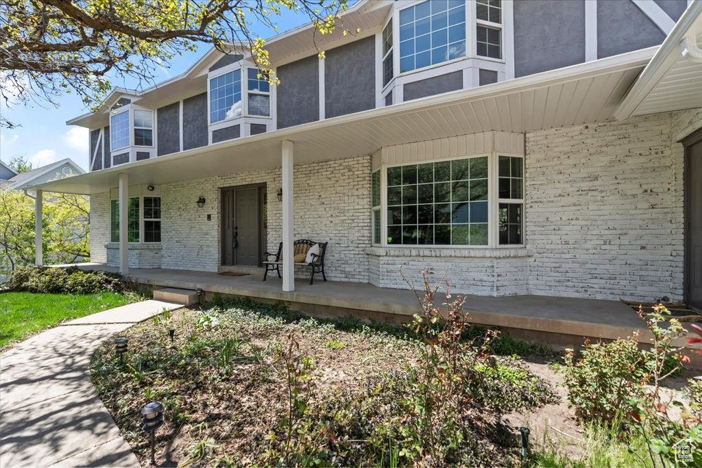 View of front of property with brick siding and covered porch