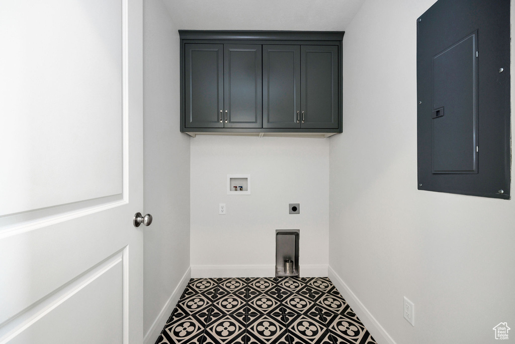 Laundry area featuring electric panel, hookup for a washing machine, baseboards, electric dryer hookup, and cabinet space
