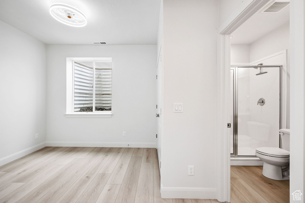 Full bathroom featuring toilet, baseboards, a shower stall, visible vents, and wood finished floors