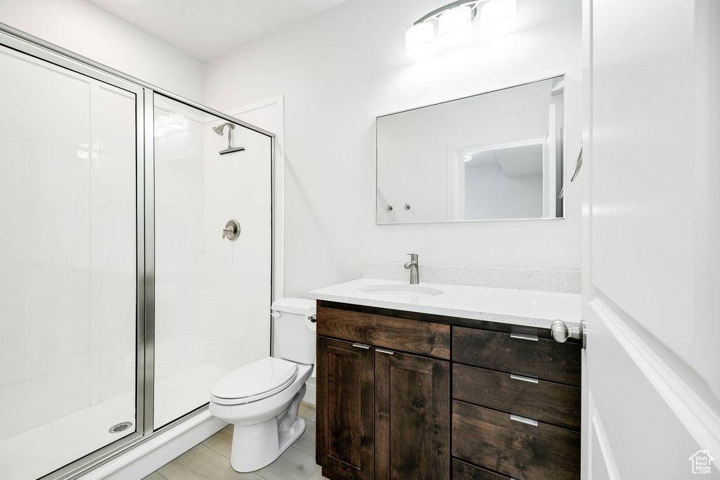 Bathroom with vanity, toilet, and a shower stall