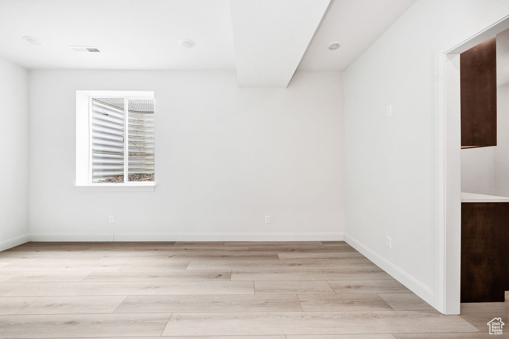 Unfurnished room with baseboards, visible vents, and light wood-style flooring