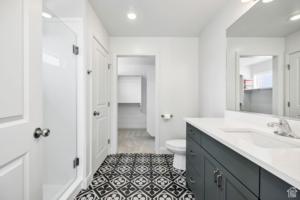 Full bathroom featuring a shower stall, baseboards, toilet, recessed lighting, and vanity