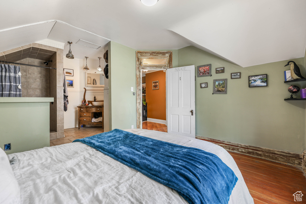 Bedroom featuring lofted ceiling and wood finished floors